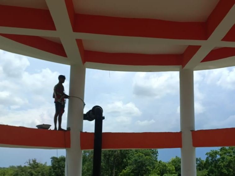 Worker on the ledge of an overhead water tank during ESR construction work
